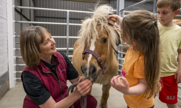 Children interacting with a pony at Craigies Farm petting area in South Queensferry