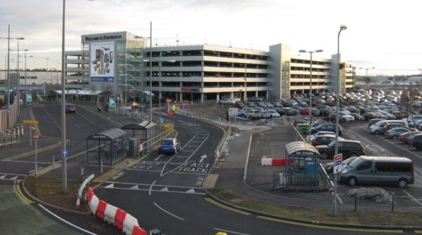 Edinburgh Airport terminal drop-off zone and multi-storey car park with Welcome to Edinburgh signage