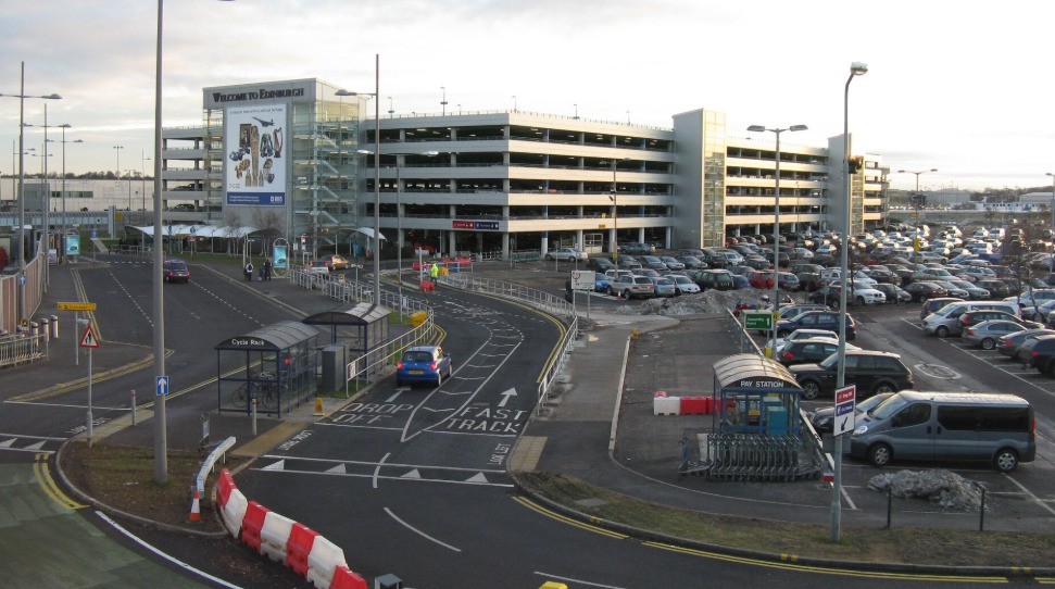 Edinburgh Airport terminal drop-off zone and multi-storey car park with Welcome to Edinburgh signage