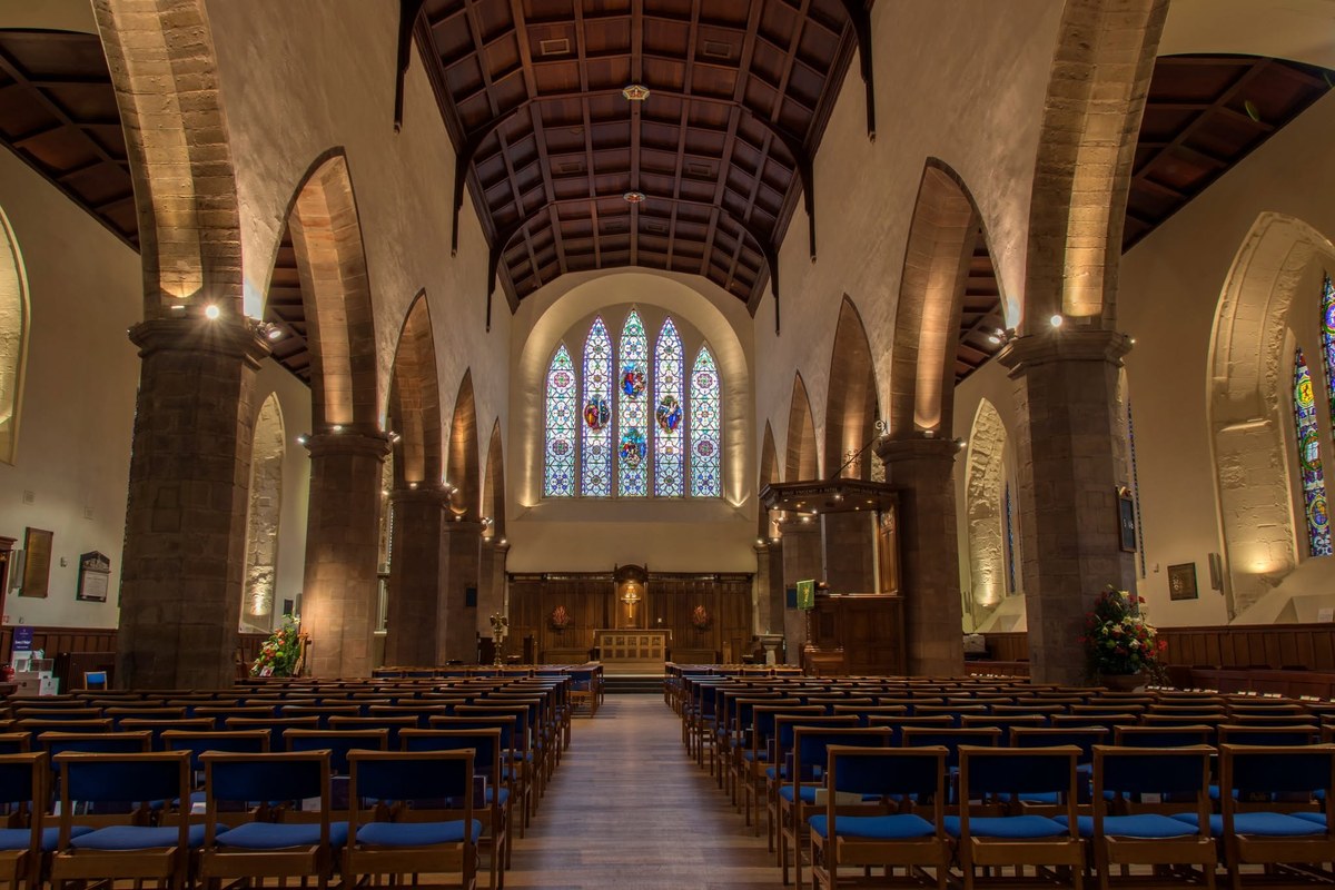 Interior of Greyfriars Kirk in Edinburgh with stone arches and stained-glass windows